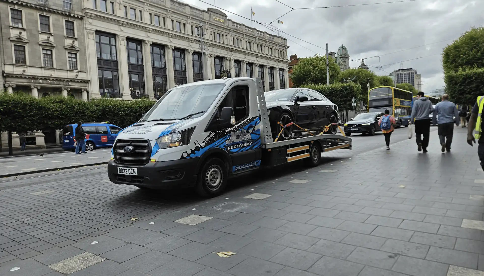 JC Recovery tow truck transporting a car in Dublin city centre